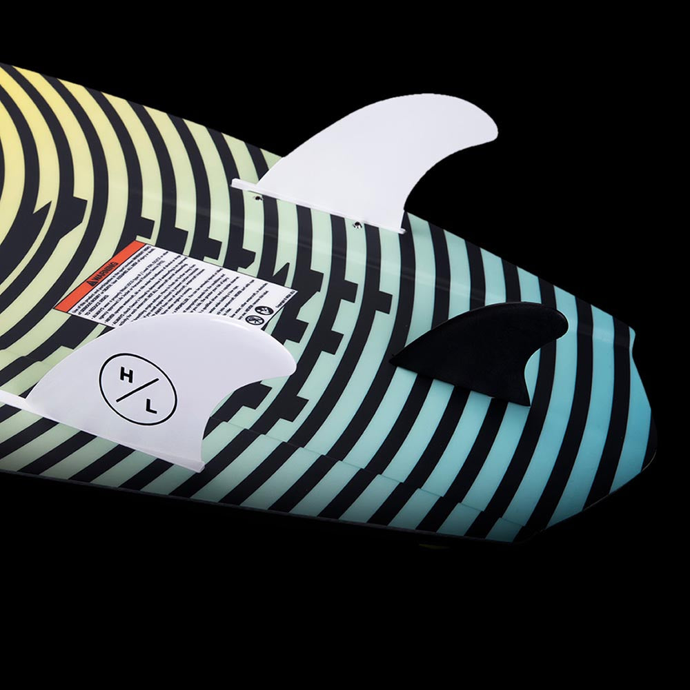 A surfboard with striped HYPERLITE Shim fins on it.